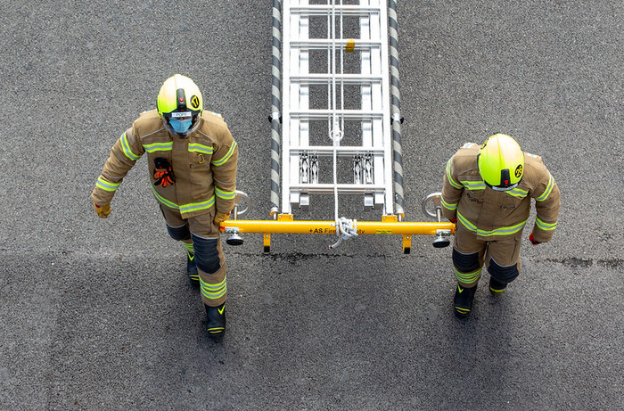 Firefighters carrying a ladder